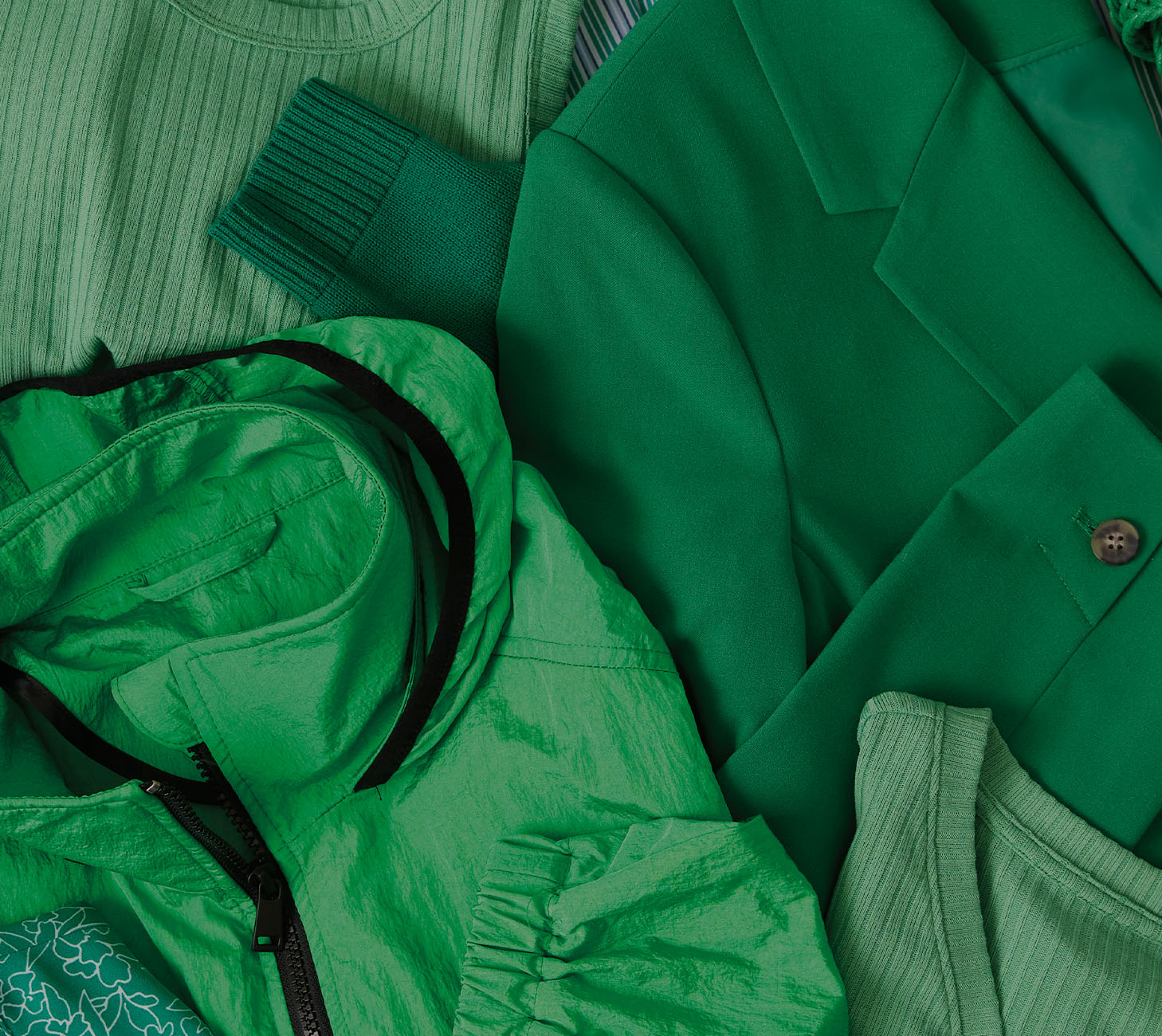 Une veste, un blazer et des pulls de couleur verte, tous étalés.