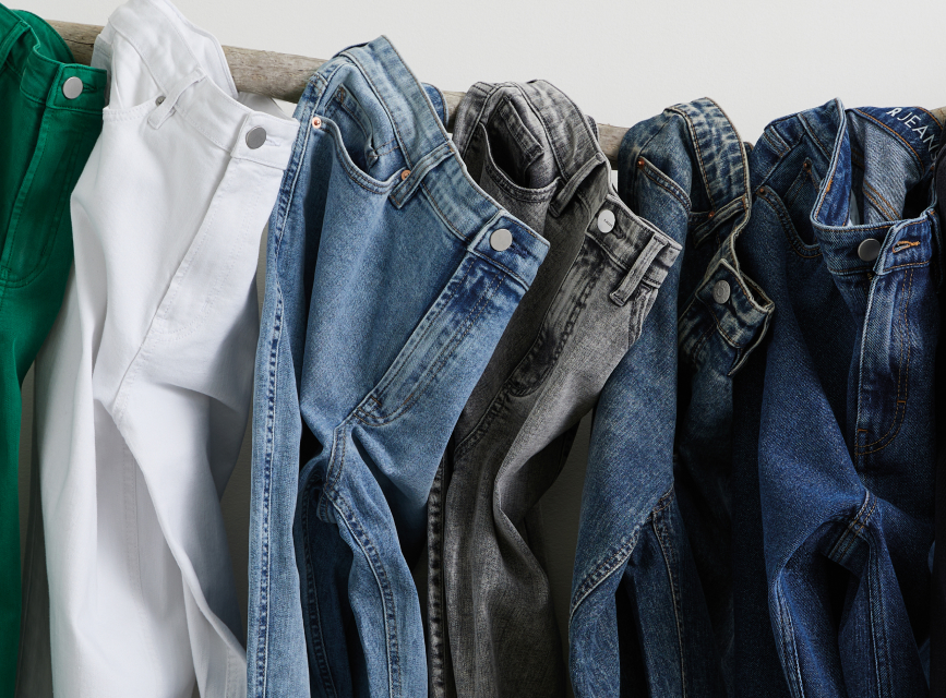 REPREVE® recycled fabrics used in jeans. 5 pairs of jeans of different washes all stacked.