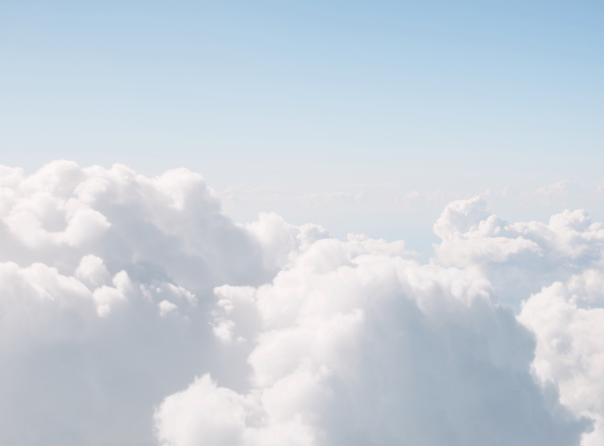 A blue sky above fluffy white clouds.