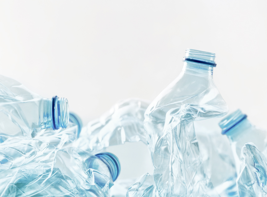 Four crumpled plastic bottles lying on the floor.