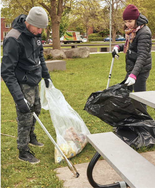 Deux personnes ramassant des déchets dans un parc.